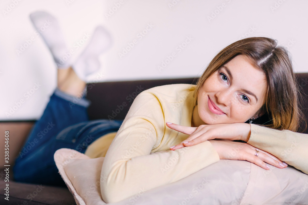 Teen lying on a sofa with her chin resting on her arms Teen lying on a sofa with her chin resting on her arms