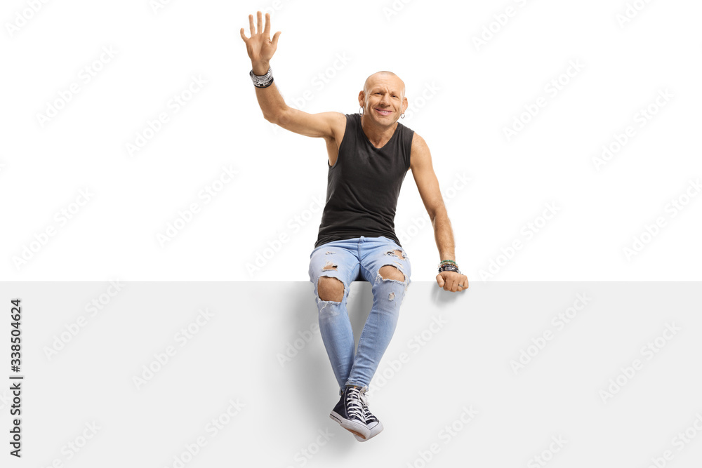 Hipster guy sitting on a panel and waving Hipster guy sitting on a panel and waving