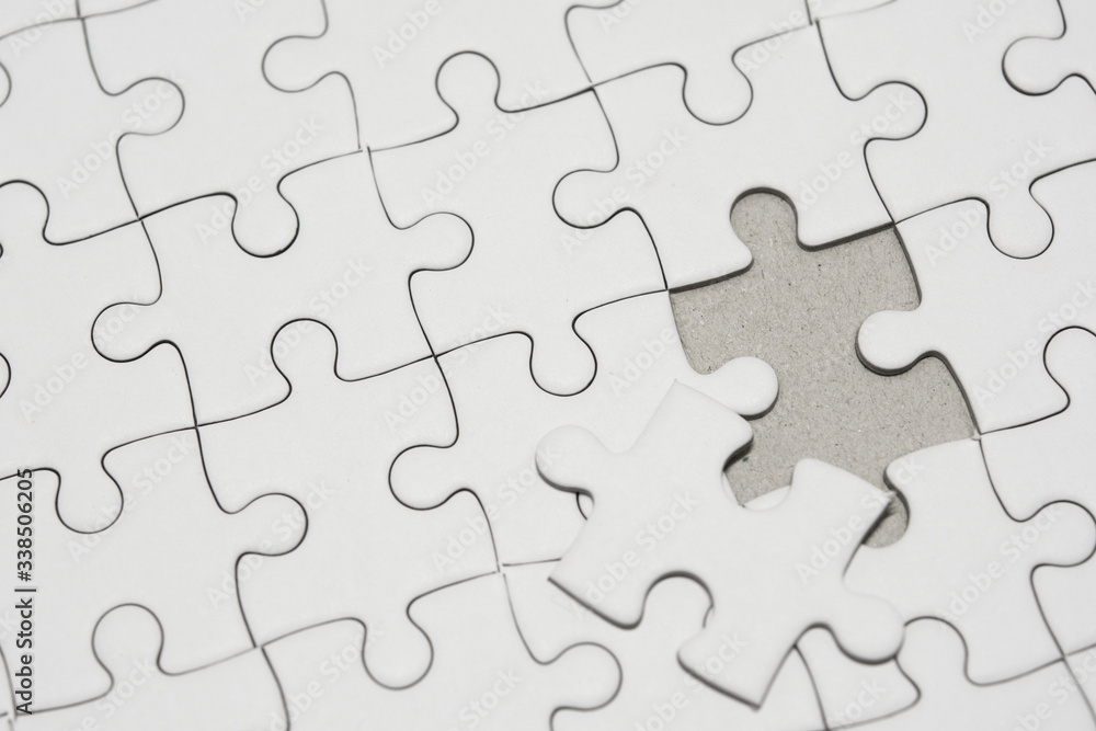 White jigsaw puzzle pattern background. placing last piece of jigsaw puzzle White jigsaw puzzle pattern background. placing last piece of jigsaw puzzle