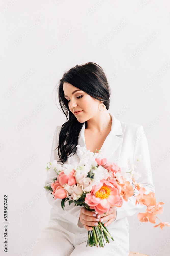 fashionable bride in a white trouser suit and with a bouquet of fashionable shades of living corals fashionable bride in a white trouser suit and with a bouquet of fashionable shades of living corals