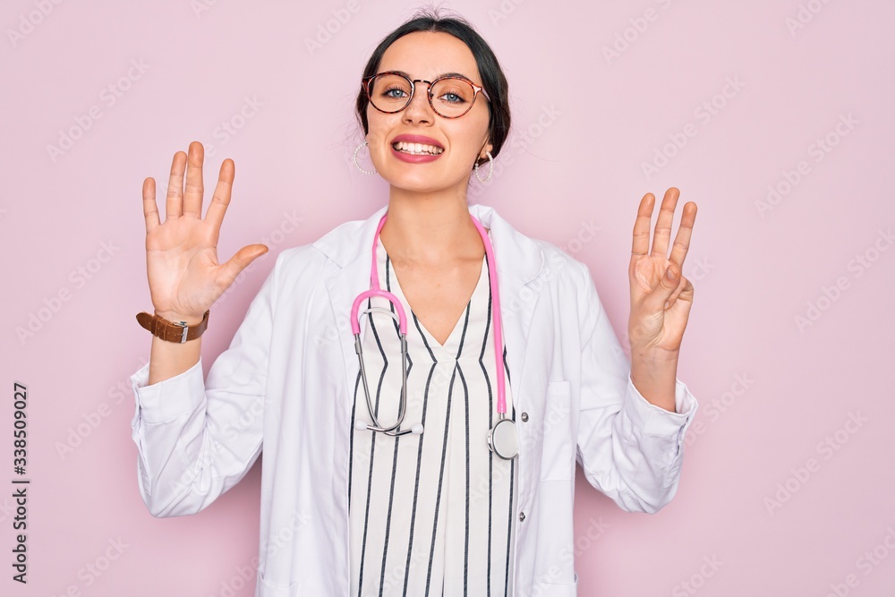 Beautiful doctor woman with blue eyes wearing coat and stethoscope over pink background showing and pointing up with fingers number eight while smiling confident and happy. Beautiful doctor woman with blue eyes wearing coat and stethoscope over pink background showing and pointing up with fingers number eight while smiling confident and happy.