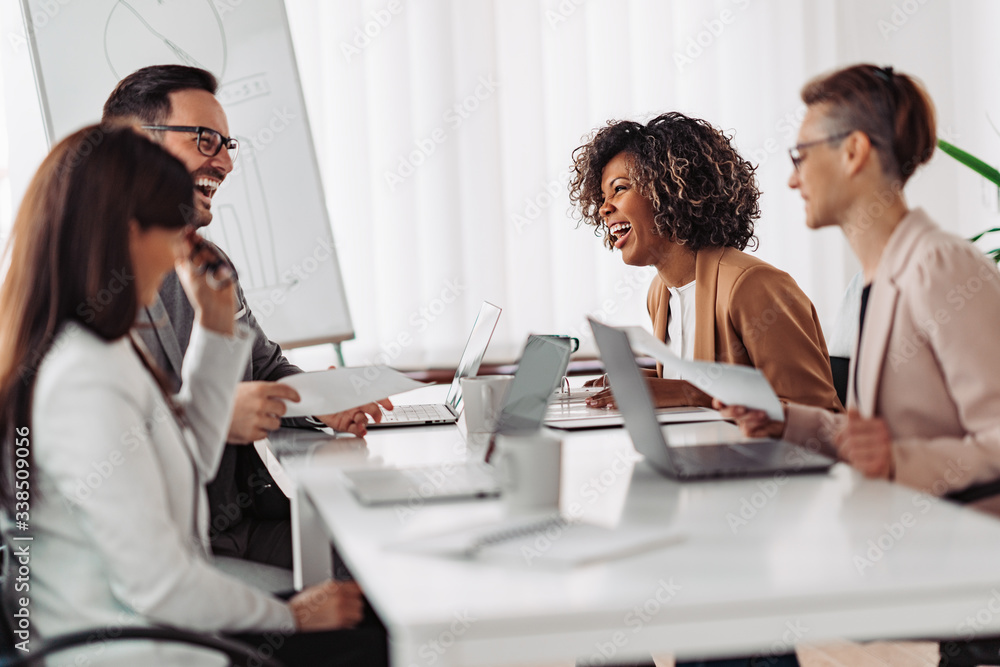 Multi ethnic group of business people having small talk and laughing Multi ethnic group of business people having small talk and laughing