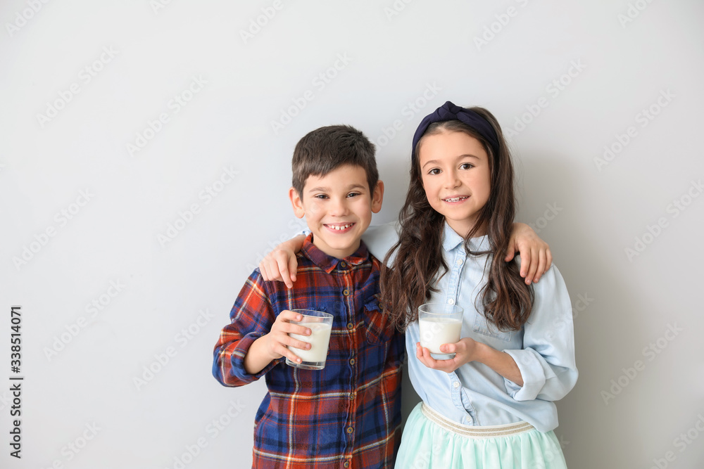 Little children drinking milk on light background Little children drinking milk on light background