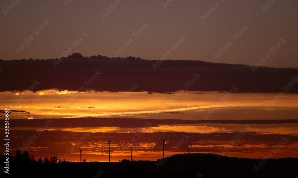 Wind turbines on a background of orange sunset sky Wind turbines on a background of orange sunset sky