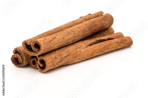 Three cinnamon sticks on a white