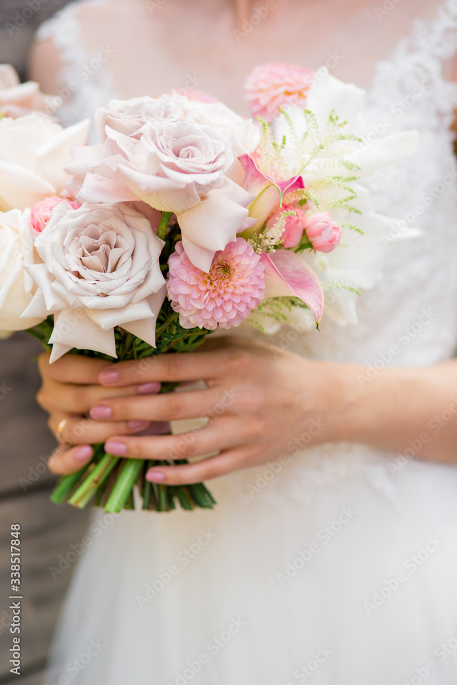 Beautiful wedding flowers in hands of the bride.