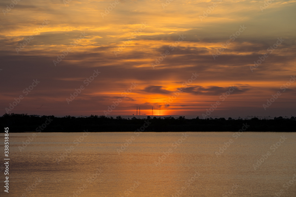 sunrise over lake, launch pad in background, cape canaveral