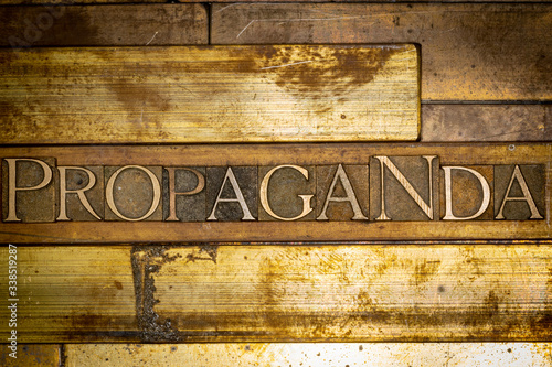 Photo of real authentic typeset letters forming Propaganda text on vintage textured grunge copper background 