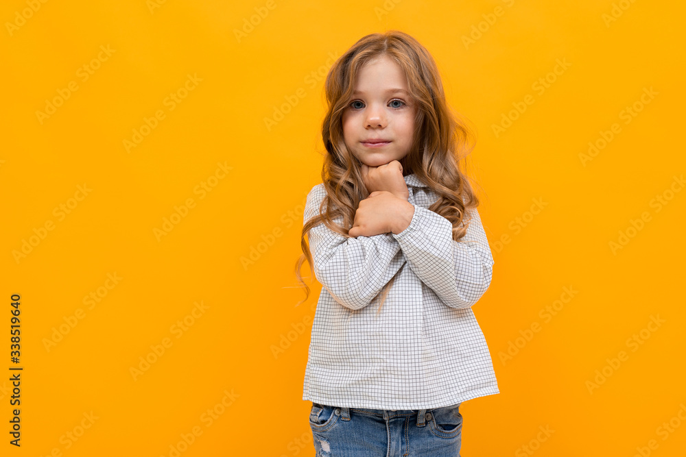Fototapeta premium Portrait of little caucasian girl is embrassed isolated on yellow background