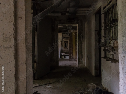 A dark and decaying corridor in an abandoned building © rememberless