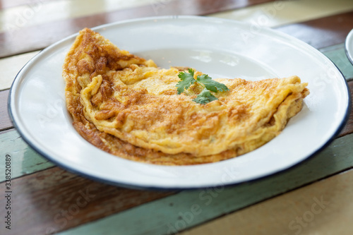 Thai style omlette classic in zinc metal plate that coating with white color on vintage table