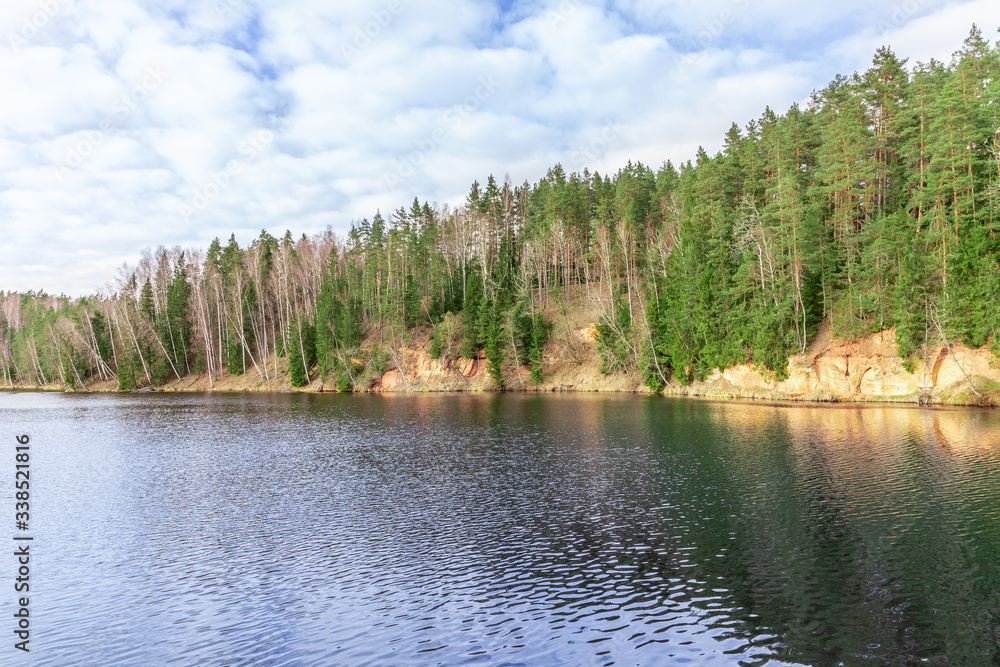 Beautiful lake in the forest with blue sky and clouds