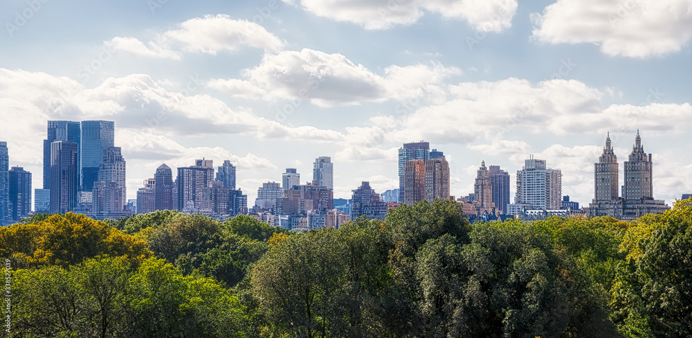 View of the Manhattan West Side with Central Park treetops in the front.