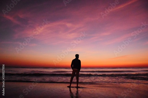 man walking on the beach at sunset