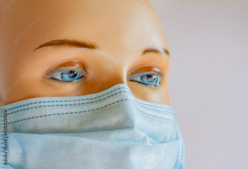 Face with blue eyes, crocheted plan, in a medical protective mask. Open space. World pandemic, Coronavirus disease 2019 and 2020, on a light background Face with blue eyes, crocheted plan, in a medical protective mask. Open space. World pandemic, Coronavirus disease 2019 and 2020, on a light background
