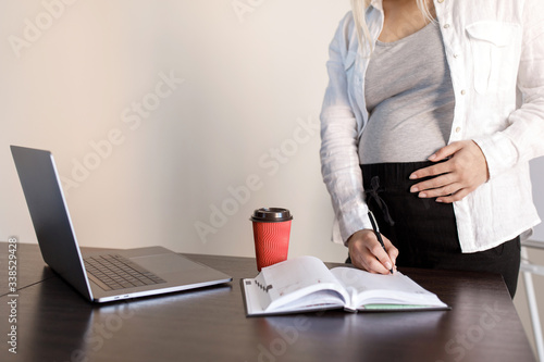 Young pretty pregnant woman is having a lesson in the room. Distance Learning. Pregnant woman running