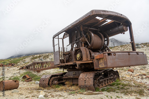 An abandoned military crane sits as rust takes over its chassis. 