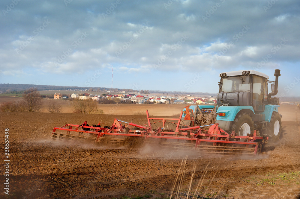 Fototapeta premium Farmers prepare the plowded land , tractor with a seeder, sowing time