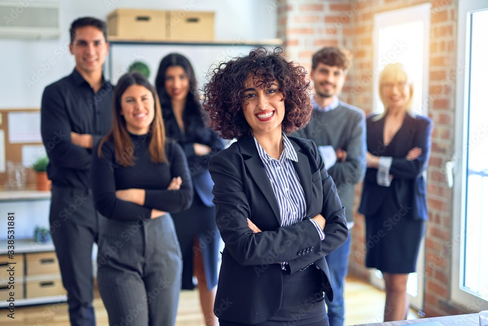 Group of business workers smiling happy and confident. Posing together with smile on face looking at the camera, young beautiful woman with crossed arms at the office Group of business workers smiling happy and confident. Posing together with smile on face looking at the camera, young beautiful woman with crossed arms at the office