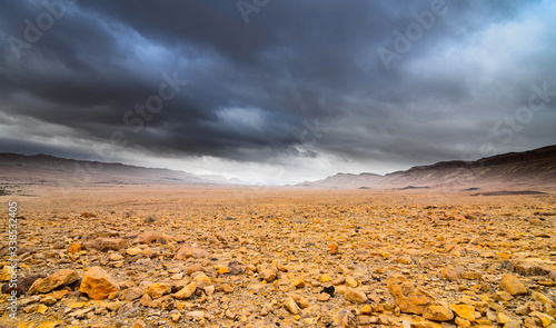 Deserted rocky landscape under the dramatic cloudy sky photo