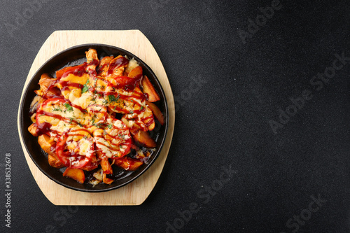 frying pan with potatoes meat and tomatoes on black concrete background. mexican food concept. potatoes fried in a pan