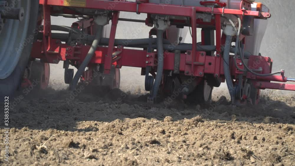 Tractor working in a field. Tractor with a seeder, sow crops at field. Sowing agricultural crops. Tractor with a seeder to sowing in a huge field. Agricultural work. Spring sowing Tractor working in a field. Tractor with a seeder, sow crops at field. Sowing agricultural crops. Tractor with a seeder to sowing in a huge field. Agricultural work. Spring sowing