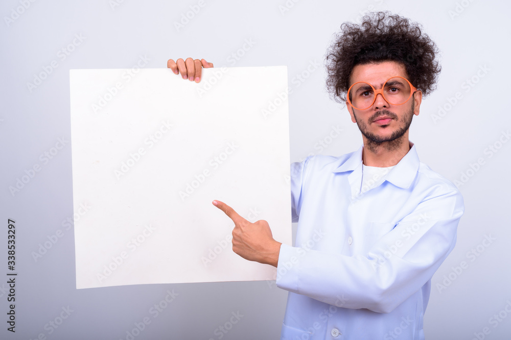 Handsome Turkish man doctor with curly hair against white background Handsome Turkish man doctor with curly hair against white background