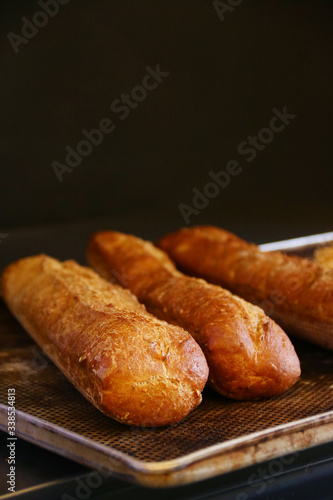 fresh baguette bread on a baking sheet and dark background