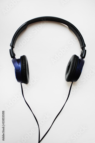 Headphones music listening technology device isolated on white background. Old black and blue color on-ear headphones, vertical top view with copy space