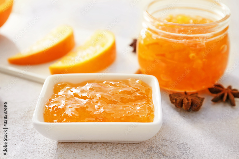 Bowl and jar of orange jam on white background Bowl and jar of orange jam on white background