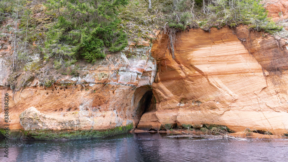 Beautiful sandstone cliff with small cave in Latvia