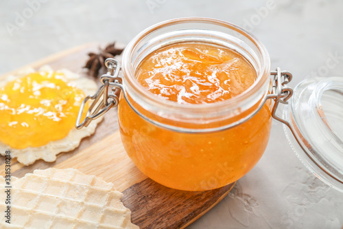 Jar of orange jam with wafers on table