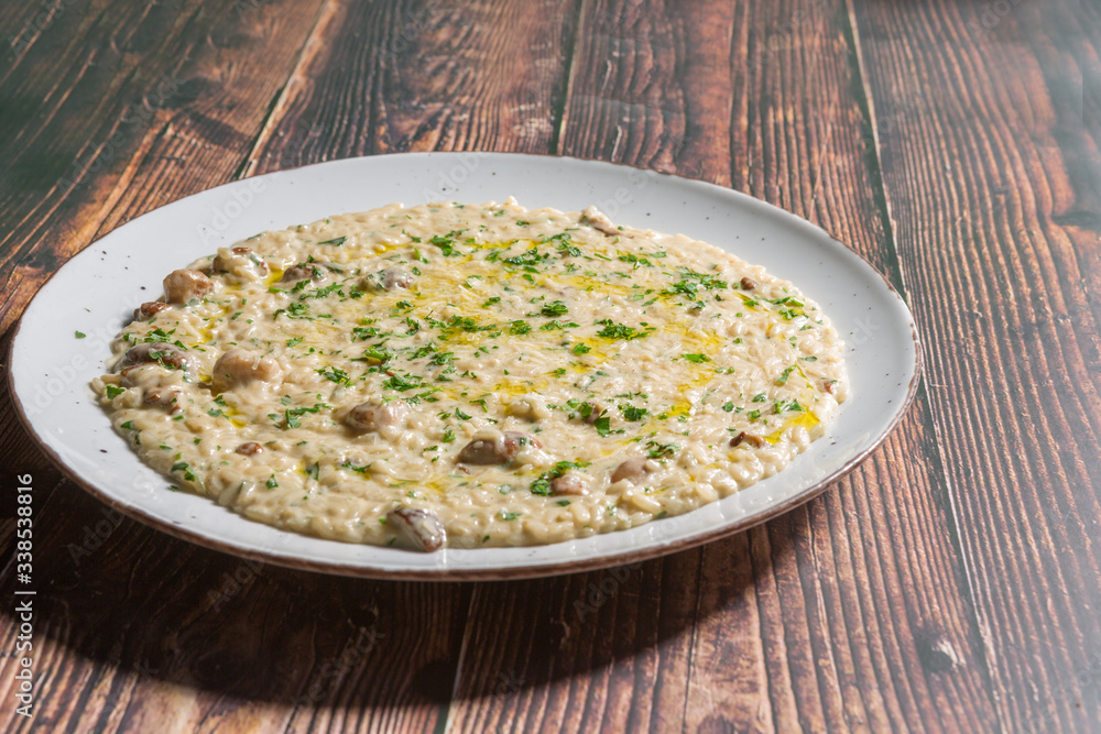 Risotto with mushrooms and cheese served on a restaurant table Risotto with mushrooms and cheese served on a restaurant table
