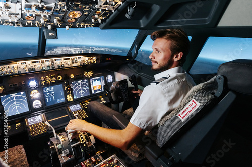 First officer is controlling autopilot and parameters for safety flight. Cockpit of Boeing aircraft. Content is good any airline. photo