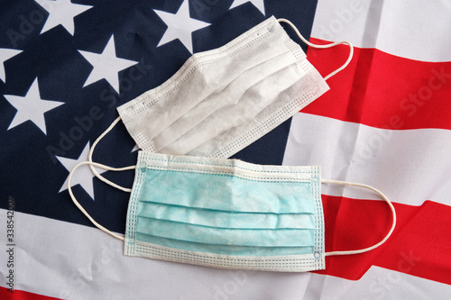 Used protective masks closeup on american flag background. Covid-19 quarantine. Flat lay, top view