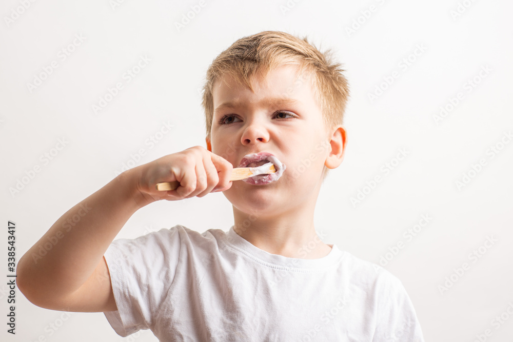 cute boy posing with bamboo toothbrush in his mouth, child brushes his teeth cute boy posing with bamboo toothbrush in his mouth, child brushes his teeth