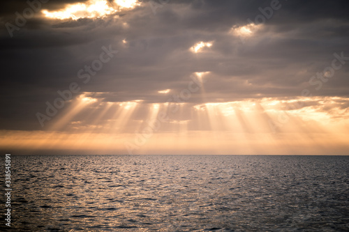 sunset on the sea with rays light across clouds.