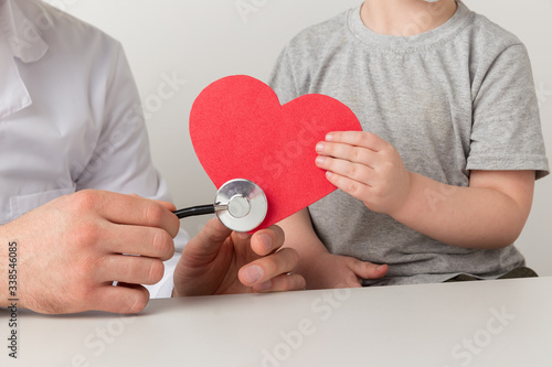 Man and kid are listening to the heart by stethoscope. Support your health concept