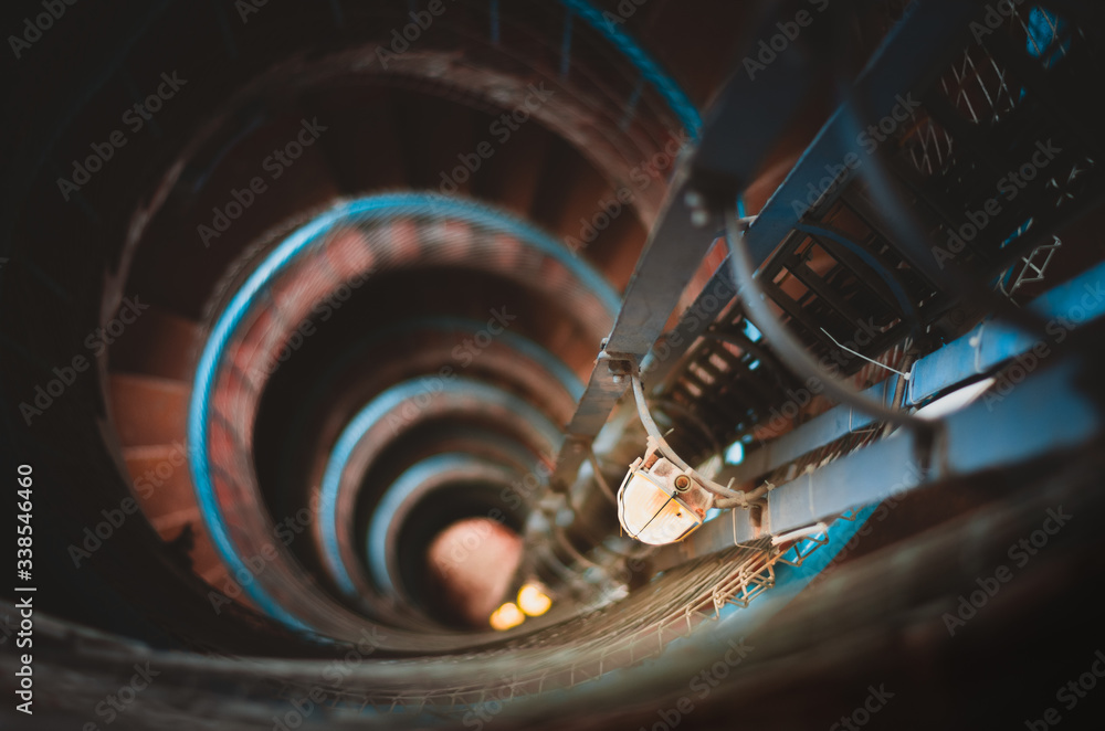 Illuminated spiral staircase inside a vintage lighthouse