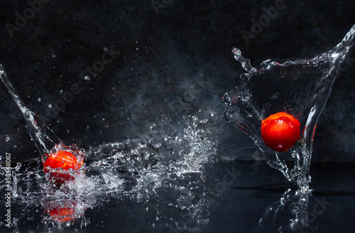 Obraz na płótnie flying red tomatoes in water drops on a gray background w salonie