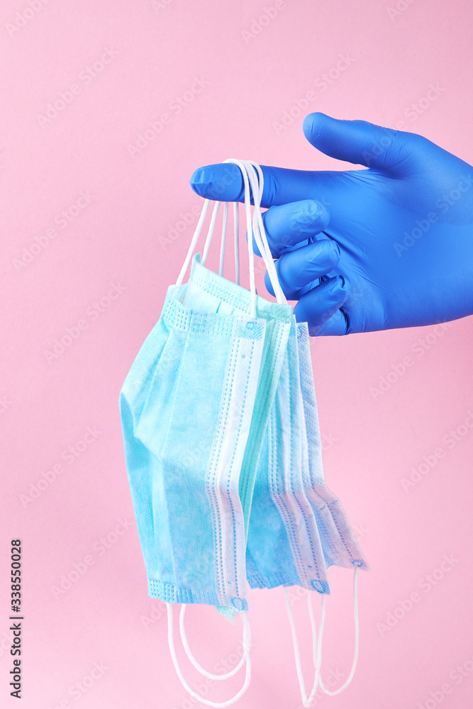 person with protective blue gloves holds surgical face masks. corona virus protection concept. vertical. person with protective blue gloves holds surgical face masks. corona virus protection concept. vertical.