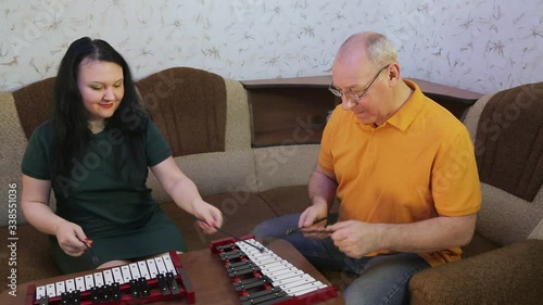 A man and a woman at home playing on metal phones. photo