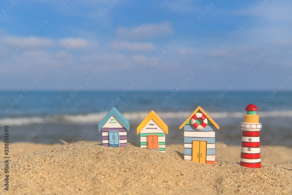 Naklejka premium Miniature huts and lighthouse at beach