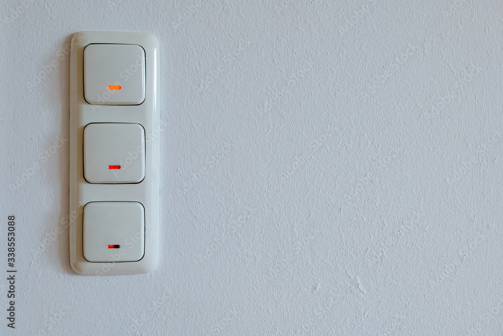Triple European light switches on white plaster interior wall. Triple European light switches on white plaster interior wall.