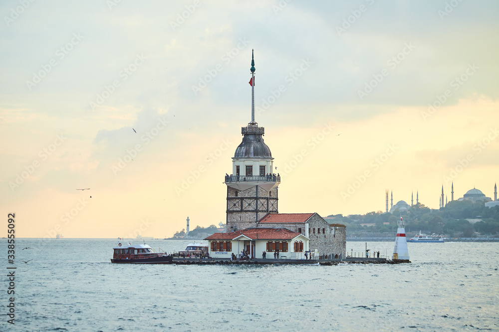 Fototapeta premium Fiery sunset over Bosphorus with famous Maiden's Tower (Kiz Kulesi in Turkish) also known as Leander's tower, symbol of Istanbul, Turkey