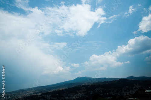 clear blue sky with clouds with mountains and house in mexico