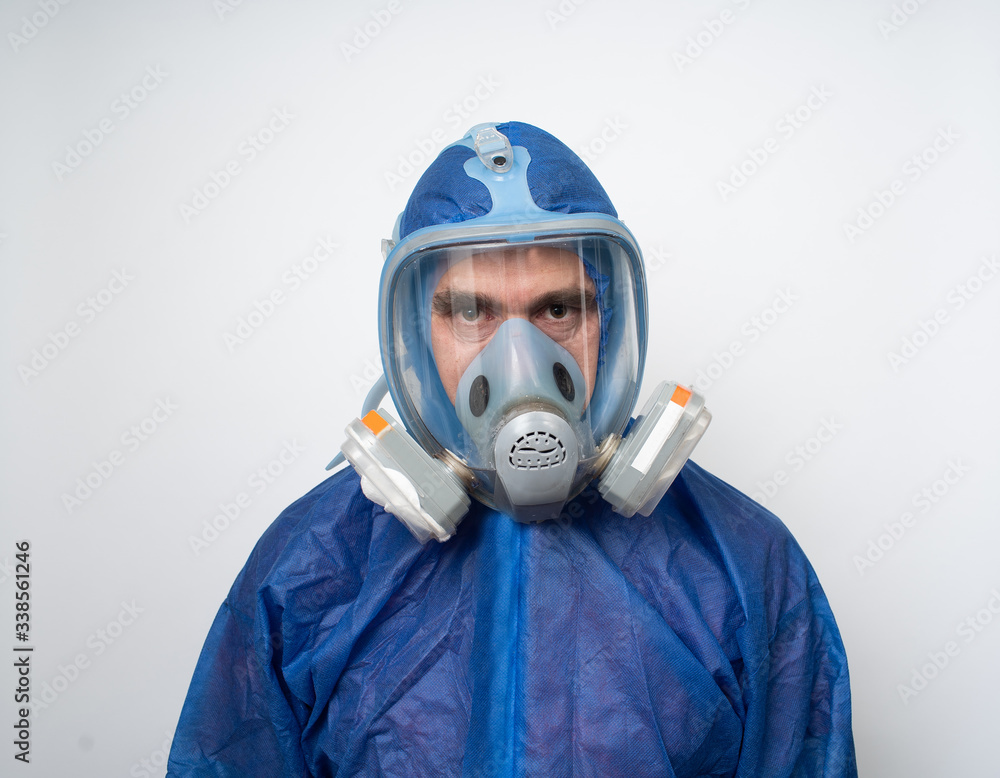a man in a protective blue suit and a protective mask close up