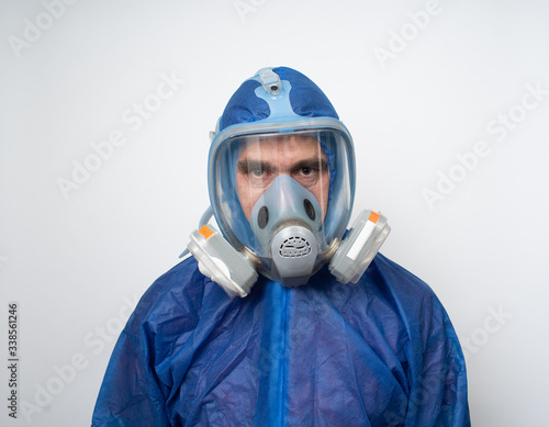 Obraz na płótnie a man in a protective blue suit and a protective mask close up w salonie