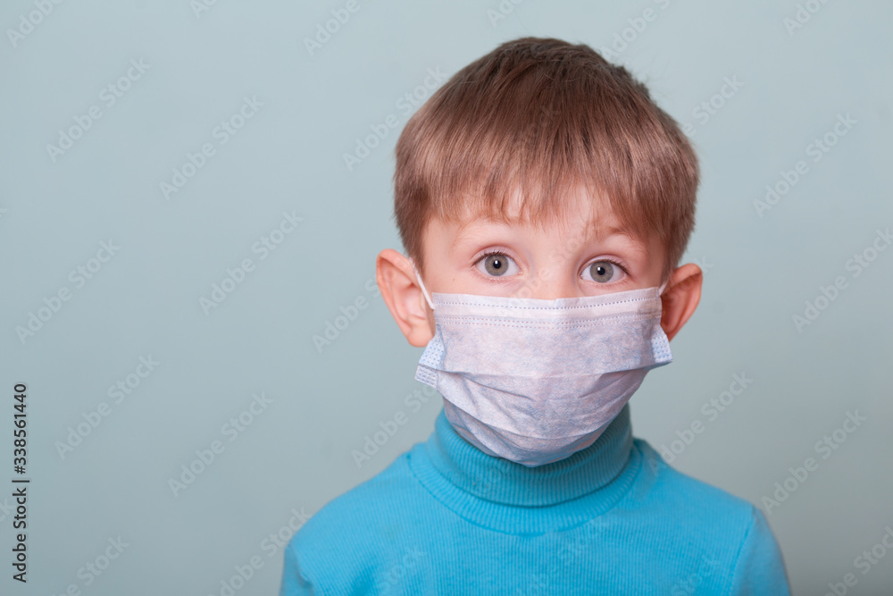 Baby boy in medical mask isolate on a blue background. Concept of coronavirus, quarantine, epidemic, pandemic, Pediatrics. Copy space Baby boy in medical mask isolate on a blue background. Concept of coronavirus, quarantine, epidemic, pandemic, Pediatrics. Copy space