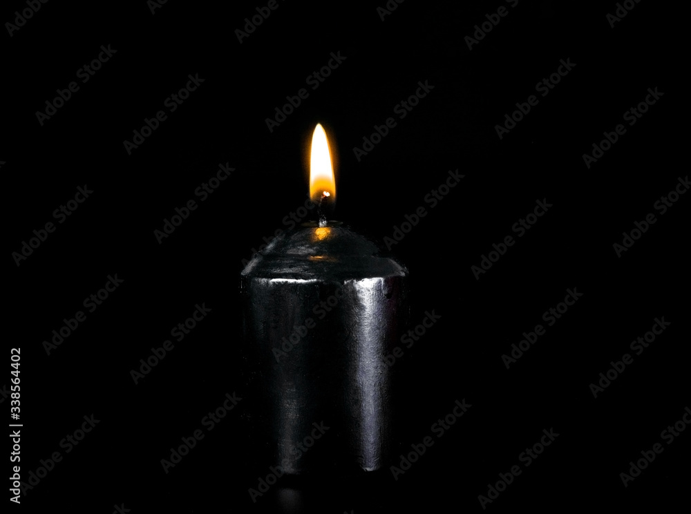 Black candle with fire on a black background. Black candle with fire on a black background.